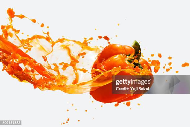 orange bell pepper & vegetables juice in the air - pepper spray stockfoto's en -beelden