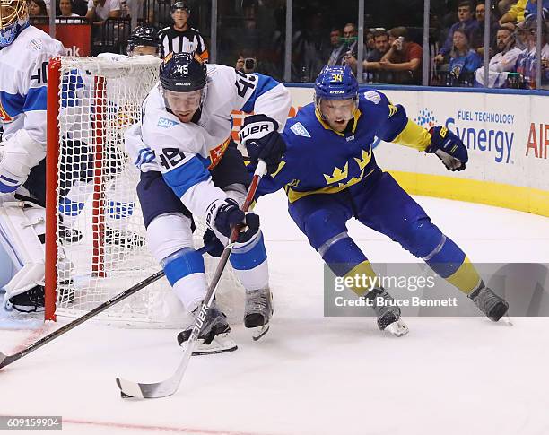 Sami Vatanen of Team Finland moves the puck away from Carl Soderberg of Team Sweden during the first period during the World Cup of Hockey tournament...