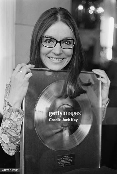 Greek singer Nana Mouskouri with her gold disc for the LP 'Over and Over', UK, 13th April 1971.