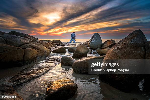 seascape, silhouette of a photographer who is shooting a sunset on the beach - photographer seascape stock pictures, royalty-free photos & images