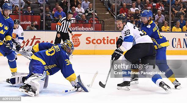 Henrik Lundqvist makes a save with Nicklas Backstrom of Team Sweden and Jussi Jokinen of Team Finland battling in front during the World Cup of...