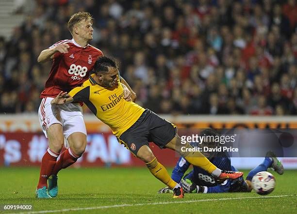 Lucas Perez scores Arsenal's 3rd goal, his 2nd, under pressure from Matt Mills of Nottingham Forest during the match between Nottingham Forest and...