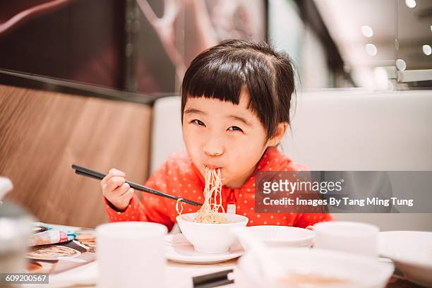 little girl having meal in restaurant - chinese girl stock pictures, royalty-free photos & images