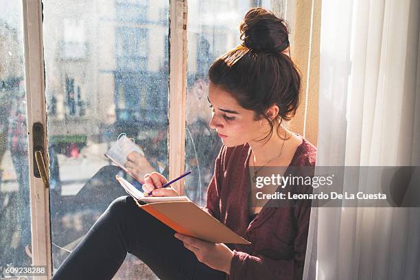 young woman writing in diary. - weite fotografías e imágenes de stock