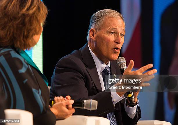 Jay Inslee, governor of Washington, right, speaks as Christy Clark, premier of British Columbia, listens during a panel discussion at the Emerging...