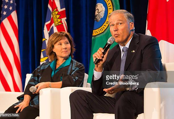Jay Inslee, governor of Washington, right, speaks as Christy Clark, premier of British Columbia, listens during a panel discussion at the Emerging...