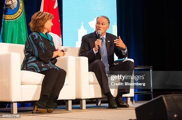 Jay Inslee, governor of Washington, right, speaks as Christy Clark, premier of British Columbia, listens during a panel discussion at the Emerging...