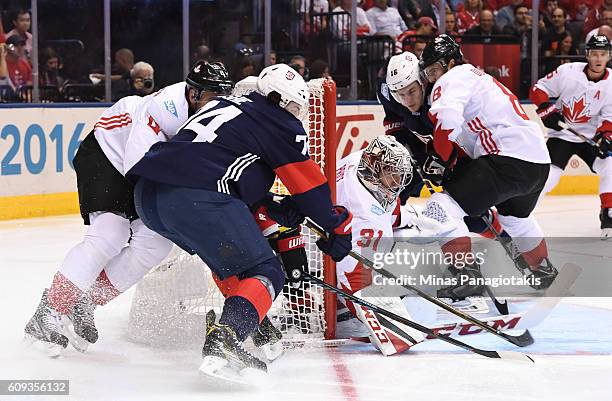 Oshie of Team USA wraps the puck around the net on Carey Price with Jay Bouwmeester of Team Canada chasing during the World Cup of Hockey 2016 at Air...