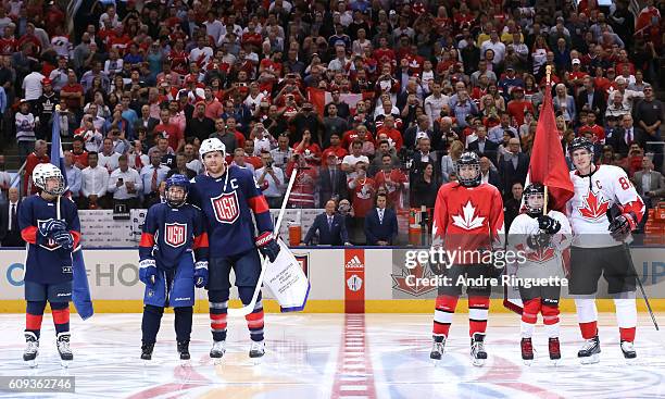 Joe Pavelski of Team USA exchanges flags with Sidney Crosby of Team Canada during the World Cup of Hockey 2016 at Air Canada Centre on September 20,...