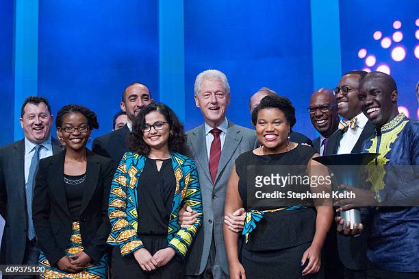 Former U.S. President Bill Clinton poses for photos with members of the Magic Bus project, the winners of the 2016 Hult Prize Award, during the...