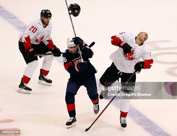 Ryan Getzlaf of Team Canada loses his helmet on a hit from Patrick Kane of Team USA in the first period during the World Cup of Hockey at the Air...