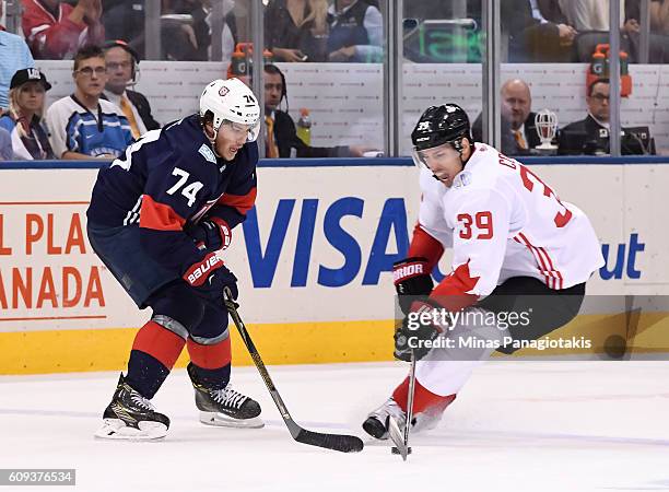 Oshie of Team USA battles for a loose puck with Logan Couture of Team Canada during the World Cup of Hockey 2016 at Air Canada Centre on September...
