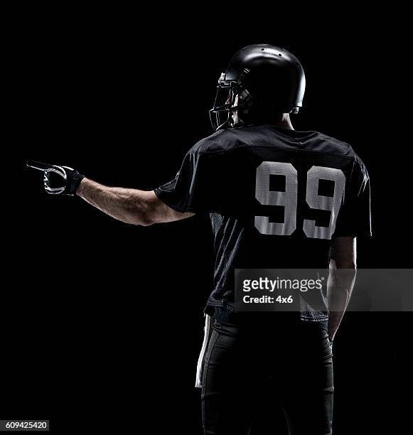 rear view of american football player pointing - american football player back stock pictures, royalty-free photos & images