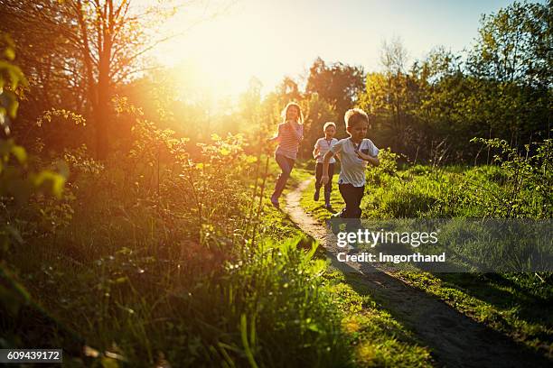 kids running in nature. - spring nature stock pictures, royalty-free photos & images