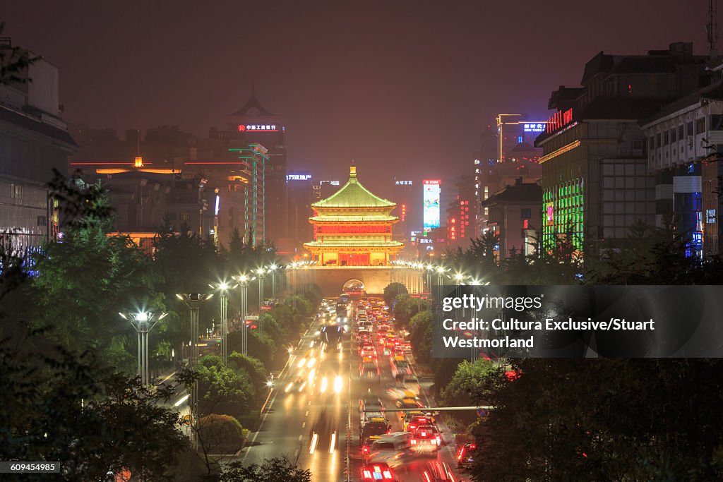 Diminishing perspective of road to Xian bell tower illuminated at night, China