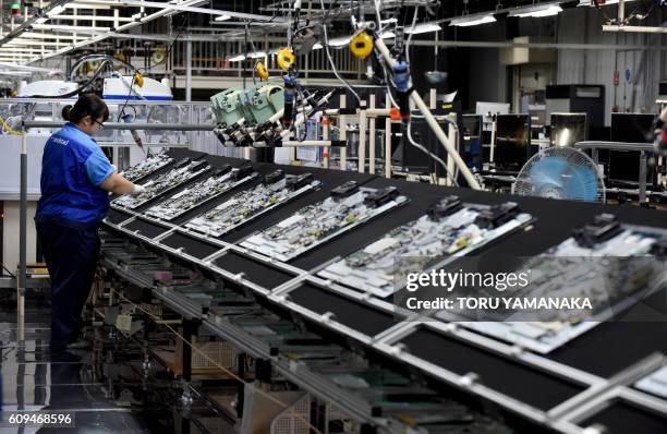 Worker assembles LCD 4K televisions on an assembly line at the Utsunomiya Plant of Japan's electronics giant Panasonic in Utsunomiya, 100 kilometres...