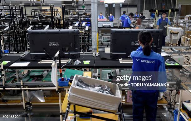 Worker checks LCD 4K televisions on an assembly line at the Utsunomiya Plant of Japan's electronics giant Panasonic in Utsunomiya, 100 kilometres...