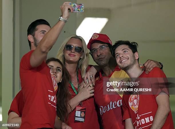 Pakistani director and bowling coach of Islamabad United Wasim Akram and his wife Shaniera Akram take a selfie during an exhibition match at...