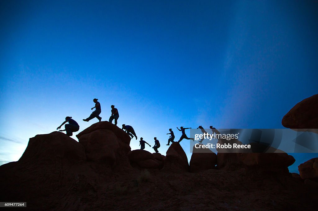 A man parkour running outdoors on rock formations in the desert