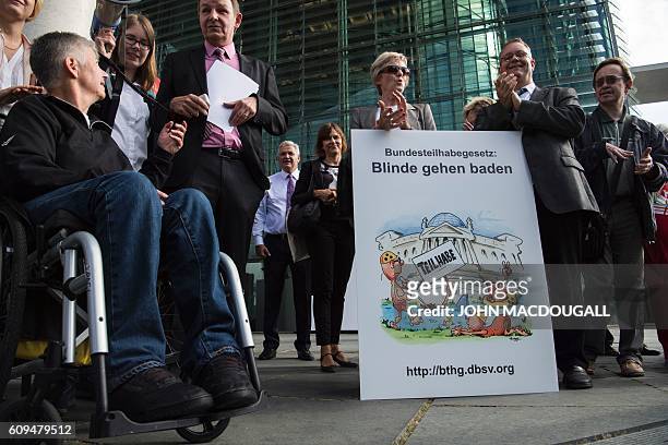 Members of the German Association for the Blind and Visually Impaired display a placard reading " blinds go swimming" during a protest which saw...