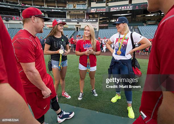 Kole Calhoun of the Los Angeles Angels of Anaheim talks with olympic gold medalists Maddie Musselman, Courtney Mathewson and Kami Craig of the United...