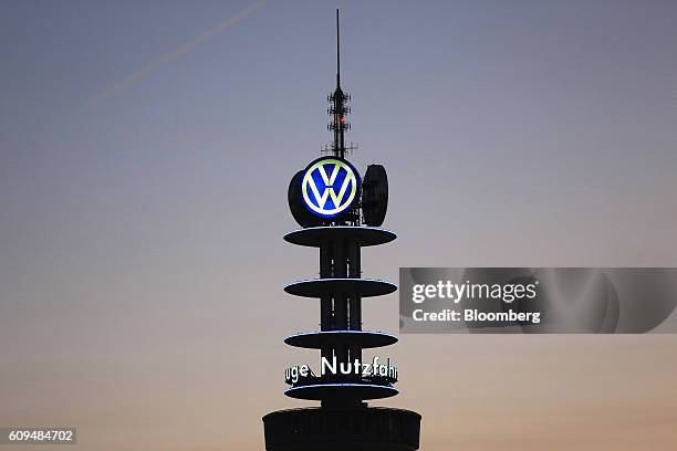 The Volkswagen AG logo sits illuminated on a television transmission mast at dawn in Hannover, Germany, on Wednesday, Sept. 21, 2016 MAN SE,...