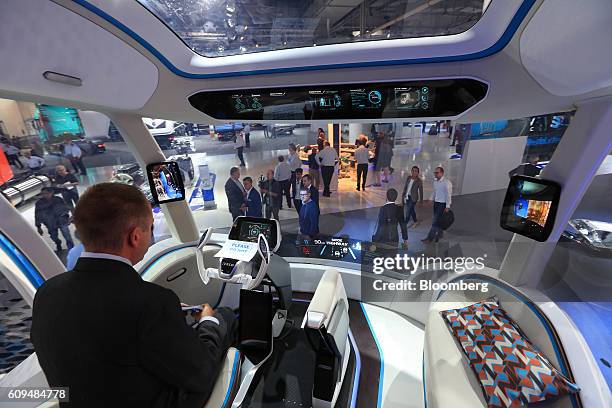An attendee sits in the driver's seat of a Iveco Z concept truck on the Iveco Ltd exhibition stand during the IAA commercial vehicle trade fair in...