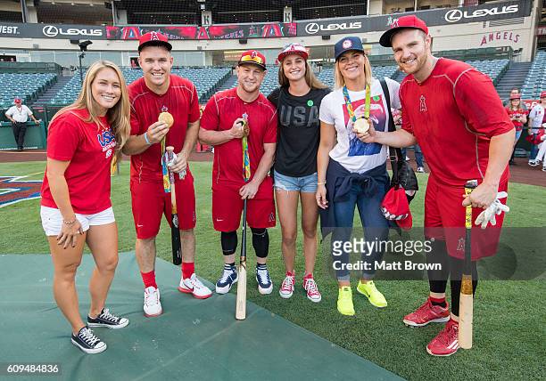 Mike Trout, Kole Calhoun and Jett Bandy of the Los Angeles Angels of Anaheim pose with olympic gold medalists, from left: Courtney Mathewson, Maddie...