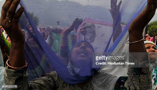 Kashmiri women pray as a head priest displays a holy relic, believed to be the hair from the beard of the Prophet Muhammad, at the Hazratbal Shrine...
