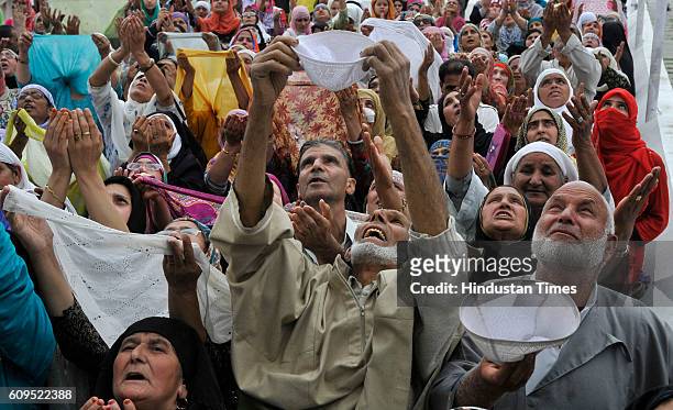 People pray as a head priest displays a holy relic, believed to be the hair from the beard of the Prophet Muhammad, at the Hazratbal Shrine on...