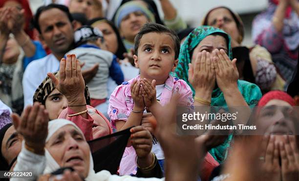 Kashmiri women pray as a head priest displays a holy relic, believed to be the hair from the beard of the Prophet Muhammad, at the Hazratbal Shrine...