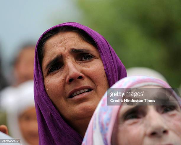 Kashmiri woman prays as a head priest displays a holy relic, believed to be the hair from the beard of the Prophet Muhammad, at the Hazratbal Shrine...