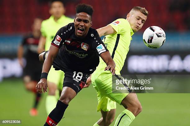 Wendell of Leverkusen is challenged by Alfred Finnbogason of Augsburg during the Bundesliga match between Bayer 04 Leverkusen and FC Augsburg at...