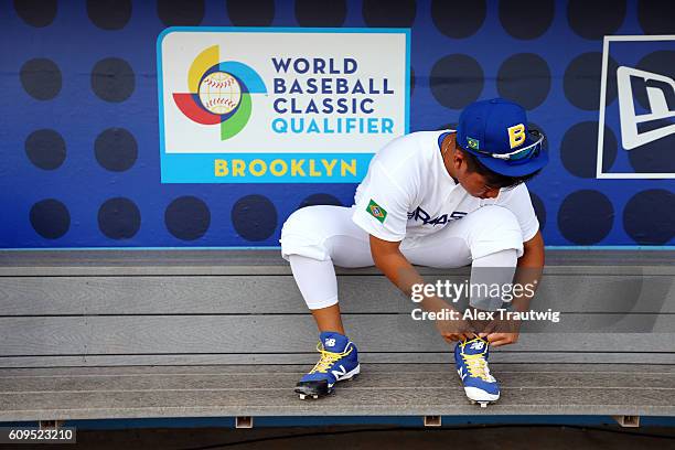 Bo Takahashi of Team Brazil ties his cleats in the dugout during workouts at MCU Park prior to the start of the 2016 World Baseball Classic Qualifier...