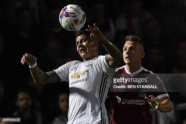 Manchester United's Argentinian defender Marcos Rojo vies with Northampton's English striker Sam Hoskins during the English League Cup third round...