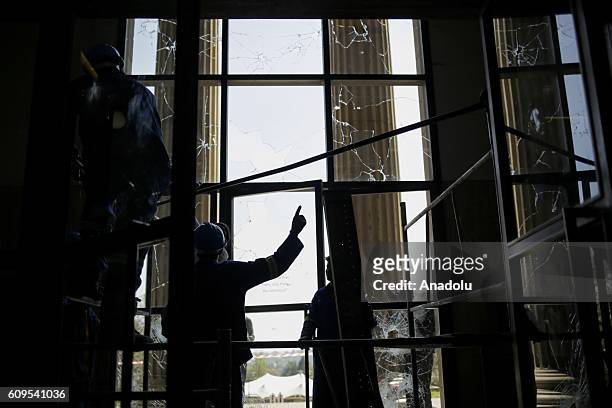 Broken windows of a building is seen as group of students gather to protest after South African Minister of Higher Education and Training Blade...