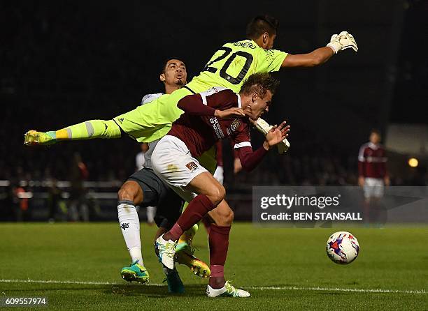 Manchester United's Argentinian goalkeeper Sergio Romero clashes with Manchester United's English defender Chris Smalling during the English League...