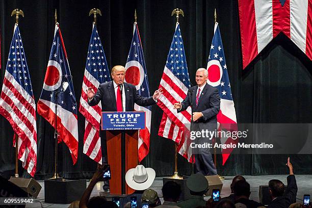 Republican presidential nominee Donald Trump welcomes his running mate, Gov. Mike Pence, to the stage as he addresses supporters at the Stranahan...