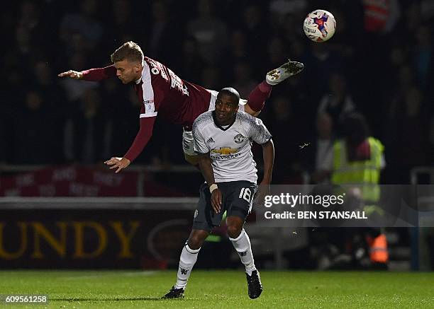 Manchester United's English midfielder Ashley Young vies with Northampton's English midfielder Alfie Potter during the English League Cup third round...