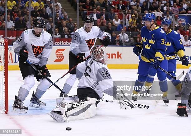 John Gibson of Team North America redirects the puck to the side of the net with Henrik Sedin of Team Sweden in front during the World Cup of Hockey...