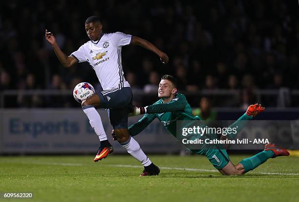 Goalkeeper Adam Smith of Northampton Town tries to hang on to Marcus Rashford of Manchester United as he goes past and scores to make it 1-3 during...