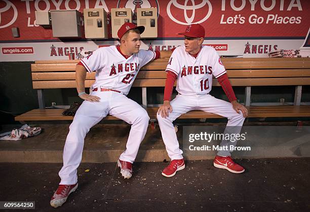 Mike Trout and third base coach Ron Roenicke of the Los Angeles Angels of Anaheim sit in the dugout before the game against the Toronto Blue Jays at...