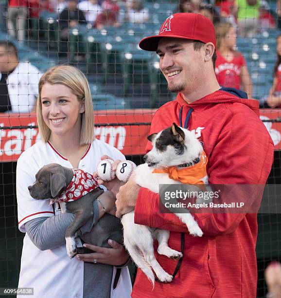 Andrew Heaney of the Los Angeles Angels of Anaheim and his wife Jordan Heaney, left, pose holding dogs on the field as part of a fundraiser run by...