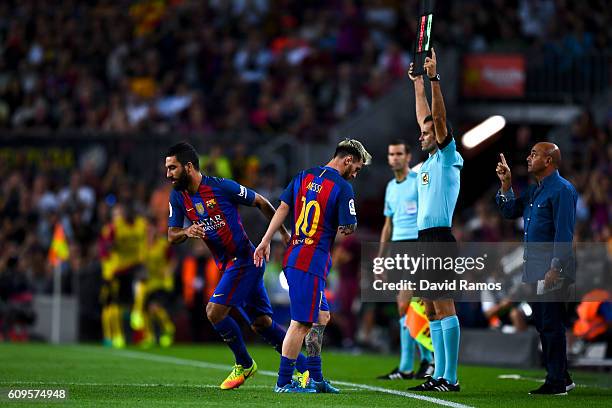 Lionel Messi of FC Barcelona is comforted by his team mate Ardan Turan of FC Barcelona as he leaves the pitch injured during the La Liga match...