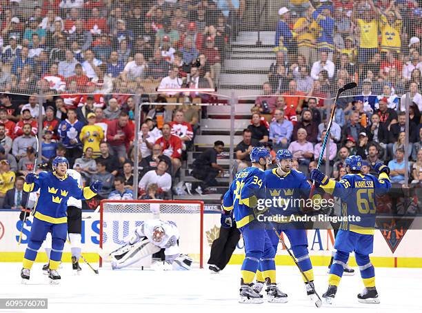 Patrik Berglund celebrates with Carl Soderberg and Erik Karlsson of Team Sweden after scoring a third period goal to against Team North America...