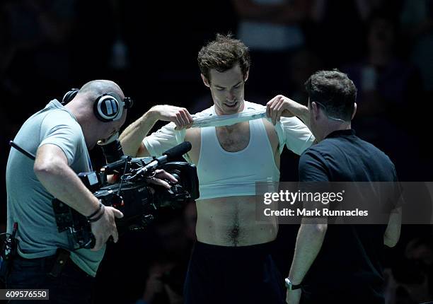 Andy Murray of Scotland shows off his body ahead of the doubles match between Andy Murray and Jamie Murray of Scotland and Tim Henman of England and...