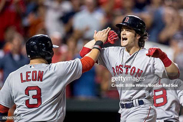 Andrew Benintendi of the Boston Red Sox high fives Sandy leon after hitting a three run home run during the sixth inning of a game against the...