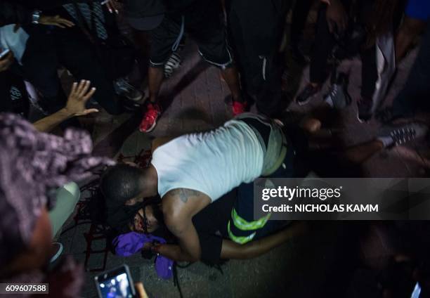 Man attends to a protester who was shot during a demonstration against police brutality in Charlotte, North Carolina, on September 21 following the...