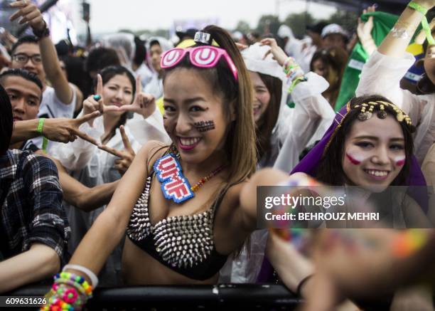 In this picture taken on September 19, 2016 Japanese girls cheer as they attend an electronic music show during the Japan Ultra Music Festival at...