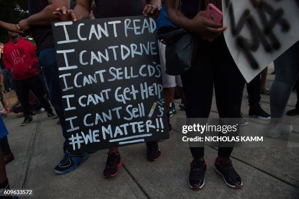 Protesters hold signs during a demonstration against police brutality in Charlotte, North Carolina, on September 21 following the shooting of Keith...